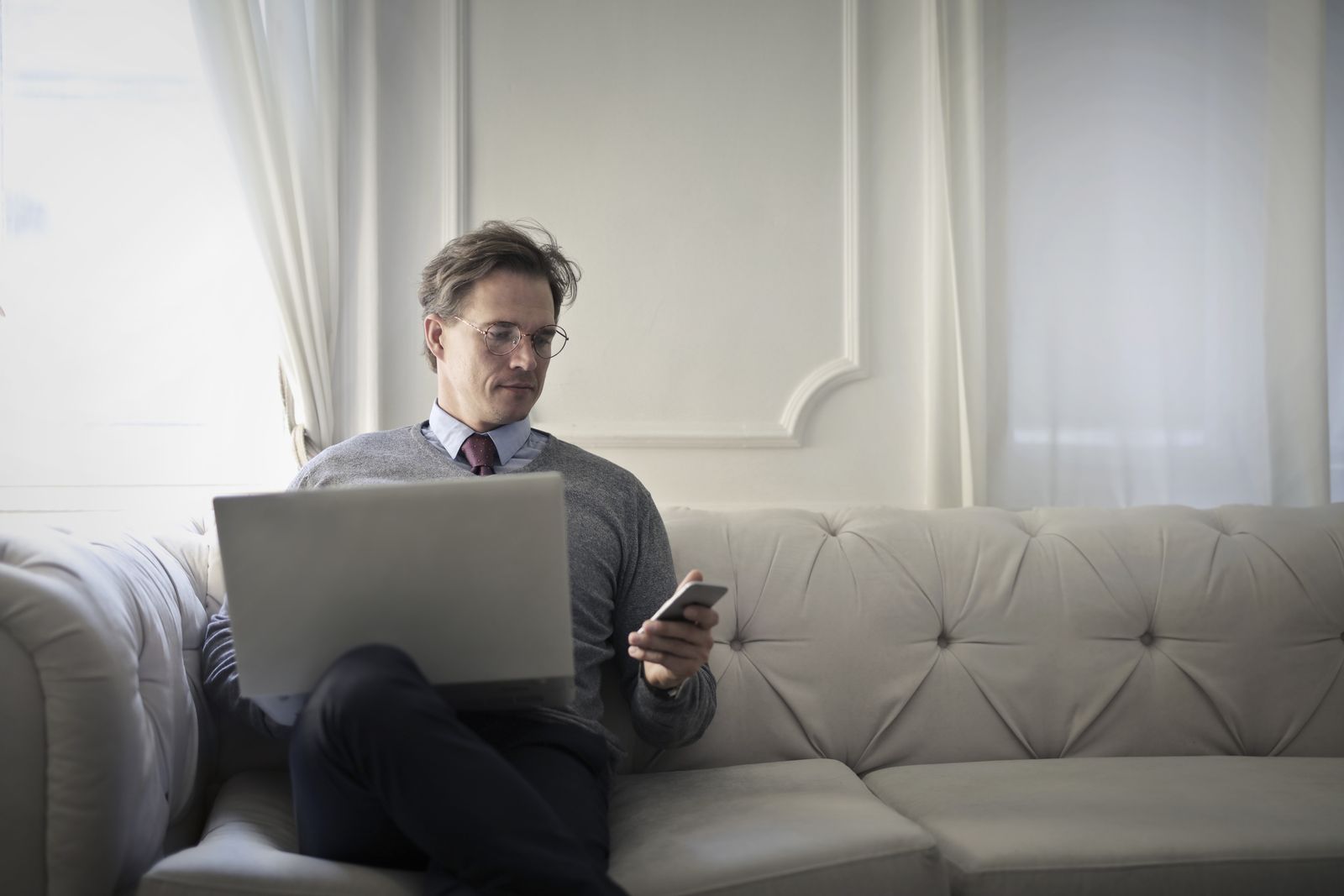 Man working on a laptop with his mobile phone nearby
