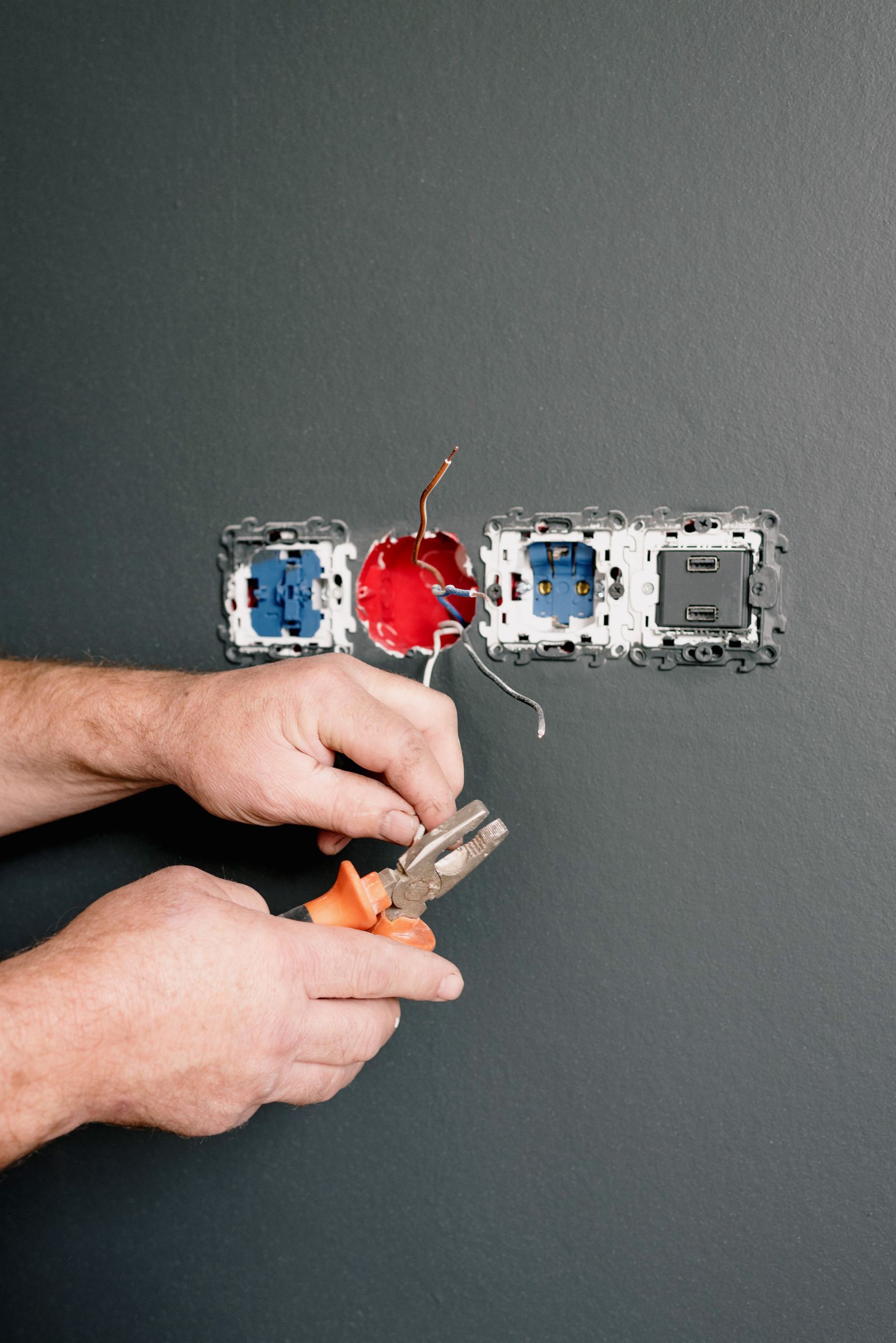 Tradie using pliers to wire power points