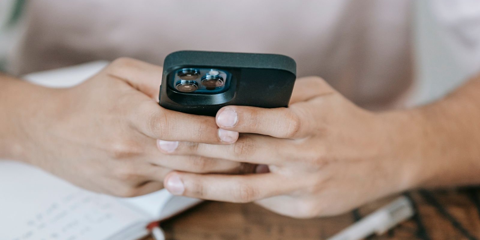 Person using a smartphone beside a laptop to send an invoice