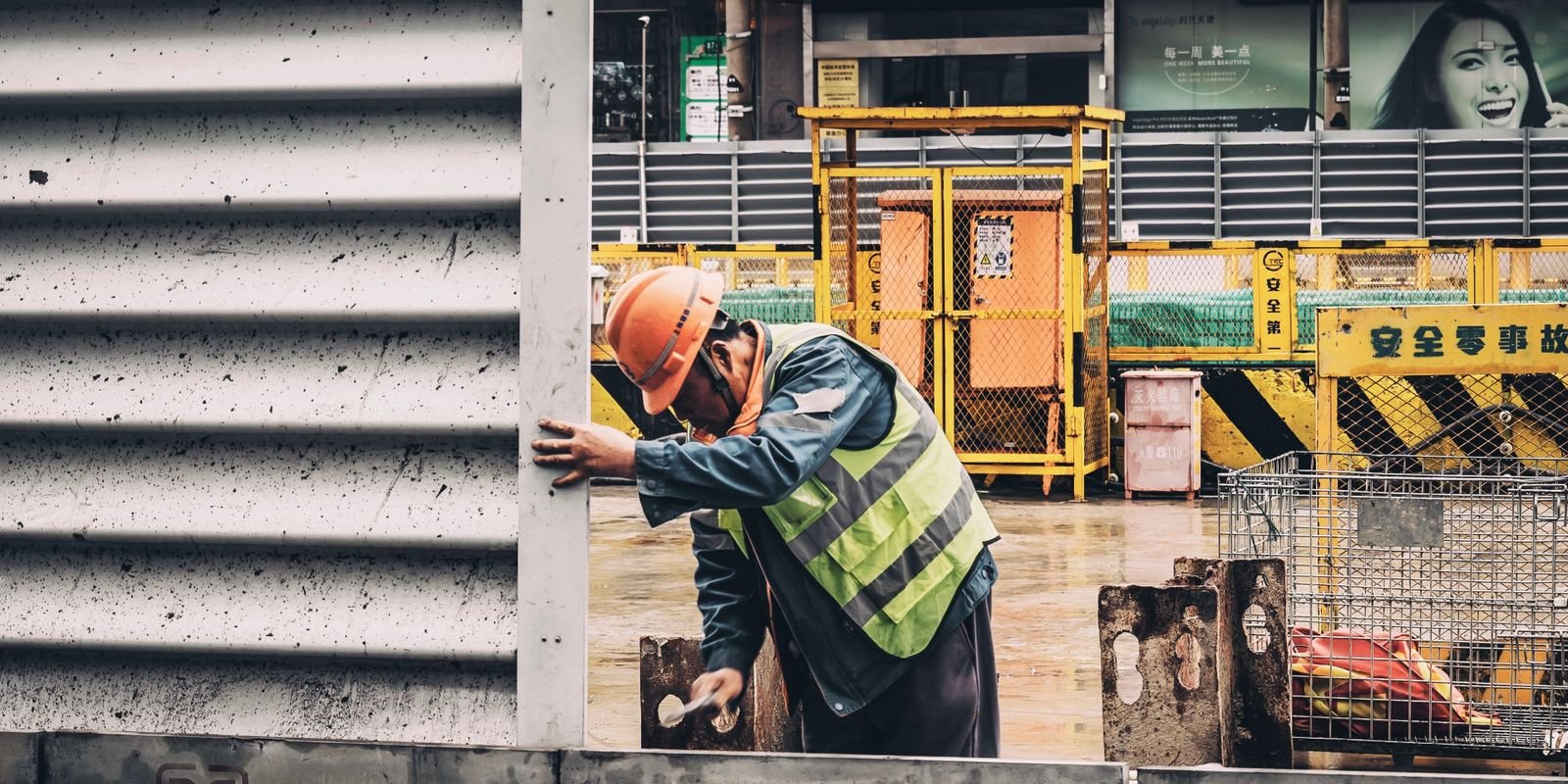 Tradie in hard hat and hi-vis vest working outdoors