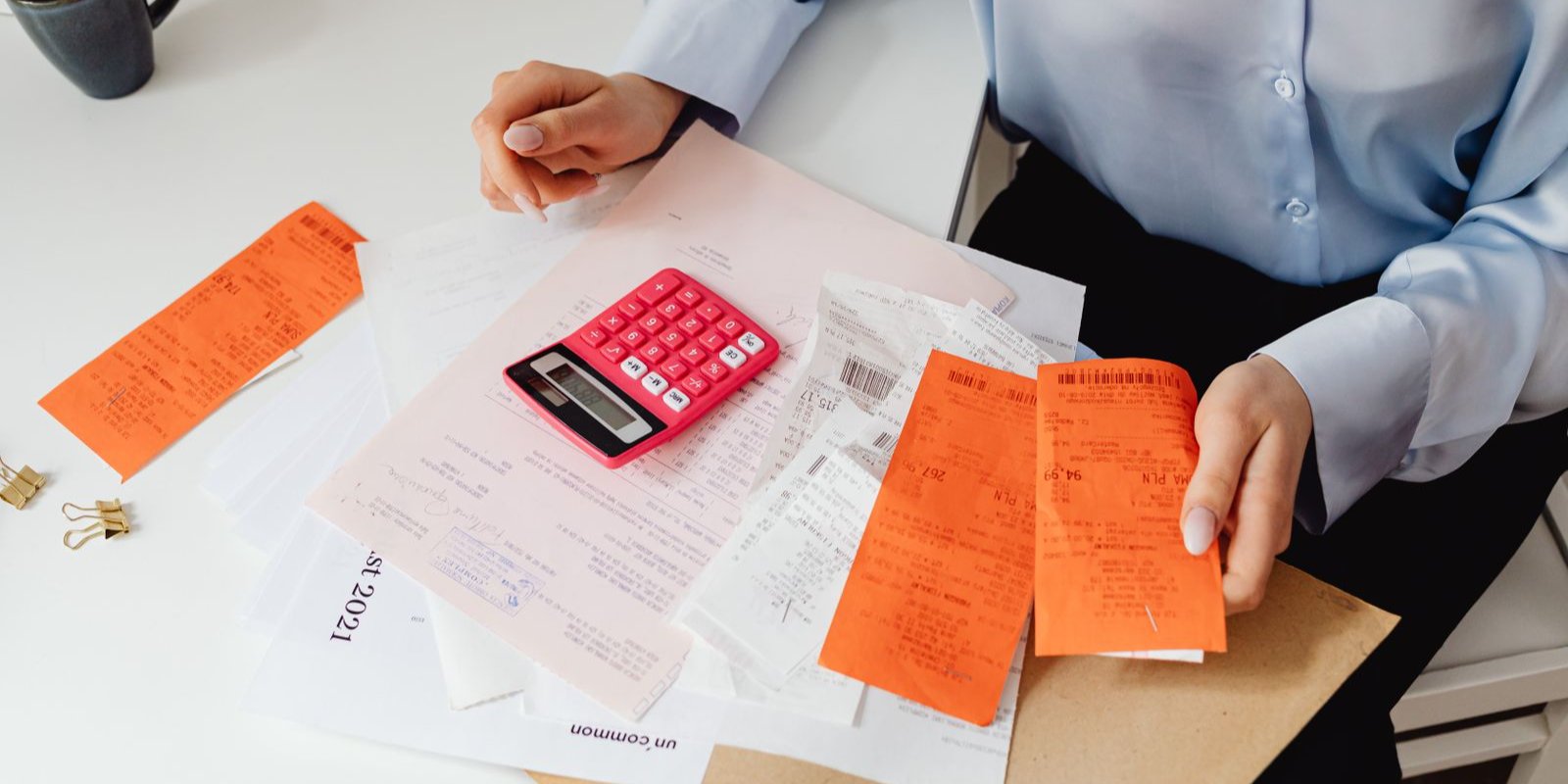 Person holding receipts and using a calculator at tax time