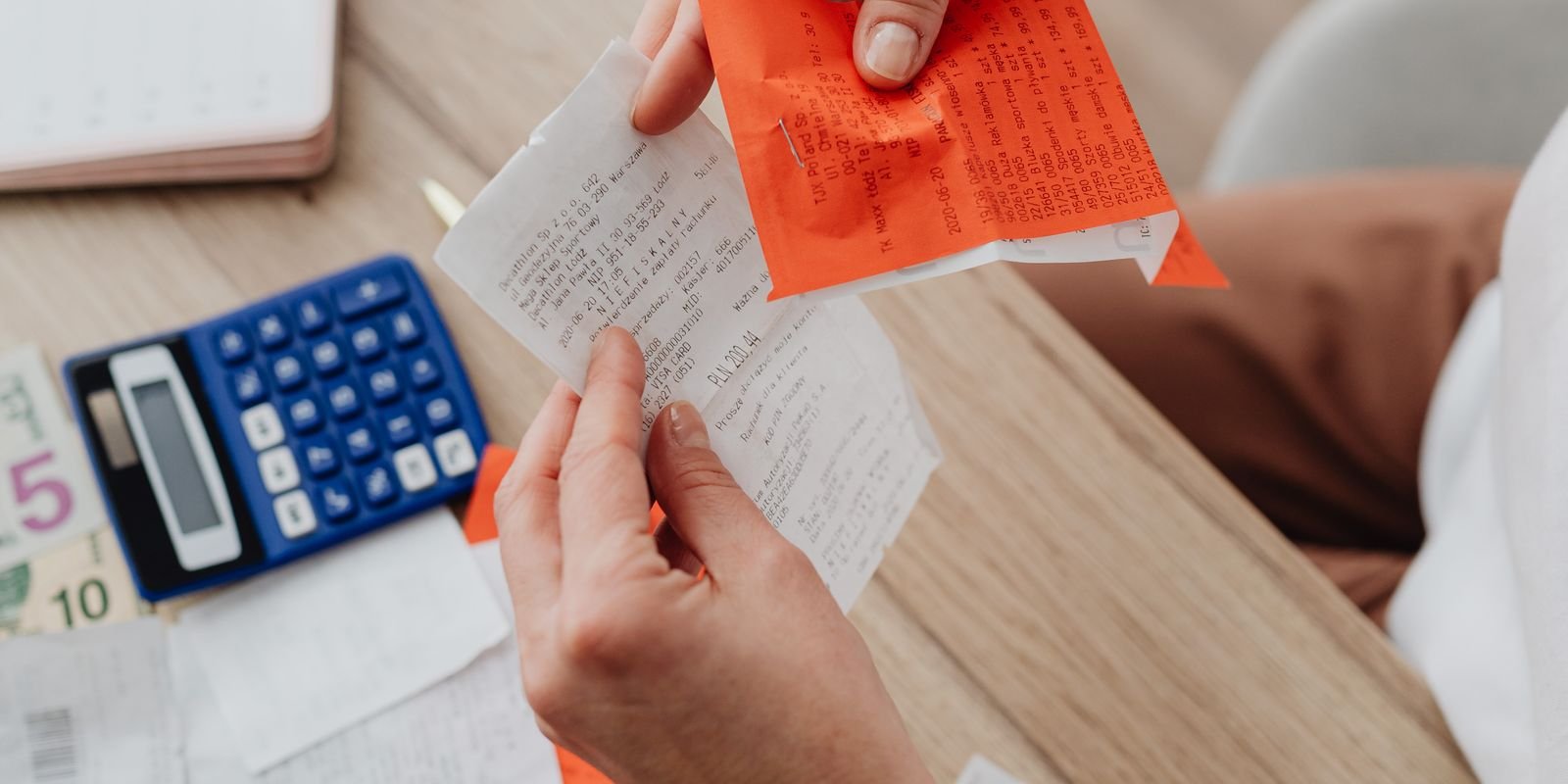 Hands holding receipts and notes for a BAS