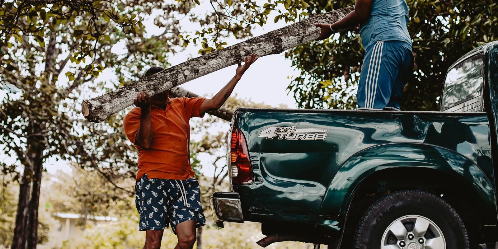 Two tradies loading timber onto a ute tray