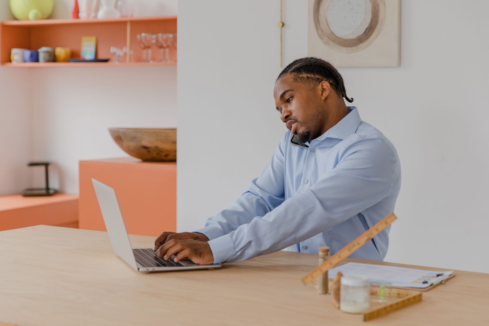 Tradie on the phone while working on a laptop