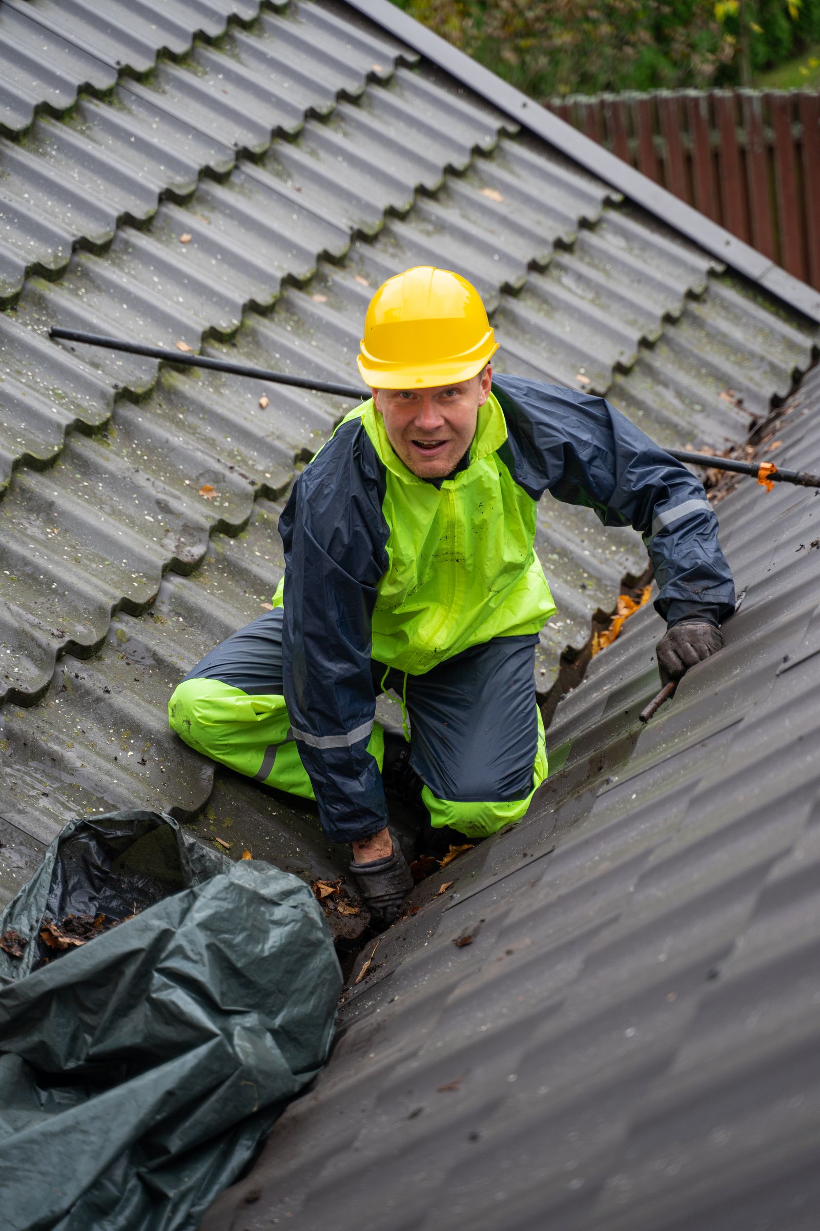 Tradie wearing a safety helmet working on a roof